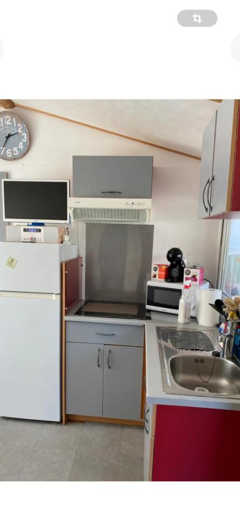 une cuisine avec un évier et un réfrigérateur blanc dans l'établissement L éden, à Hyères