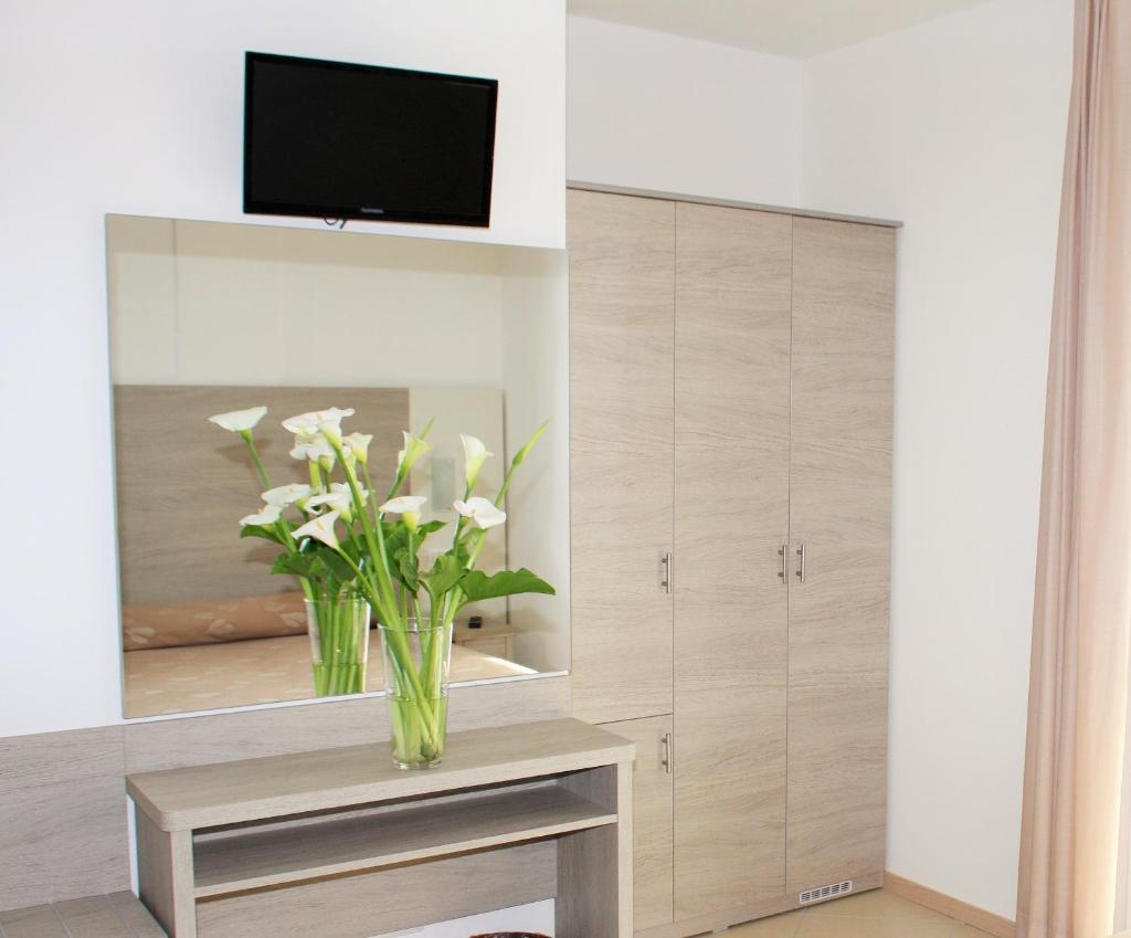 un salon avec un vase de fleurs sur une table dans l'établissement Hotel Villa Enea, à Cattolica