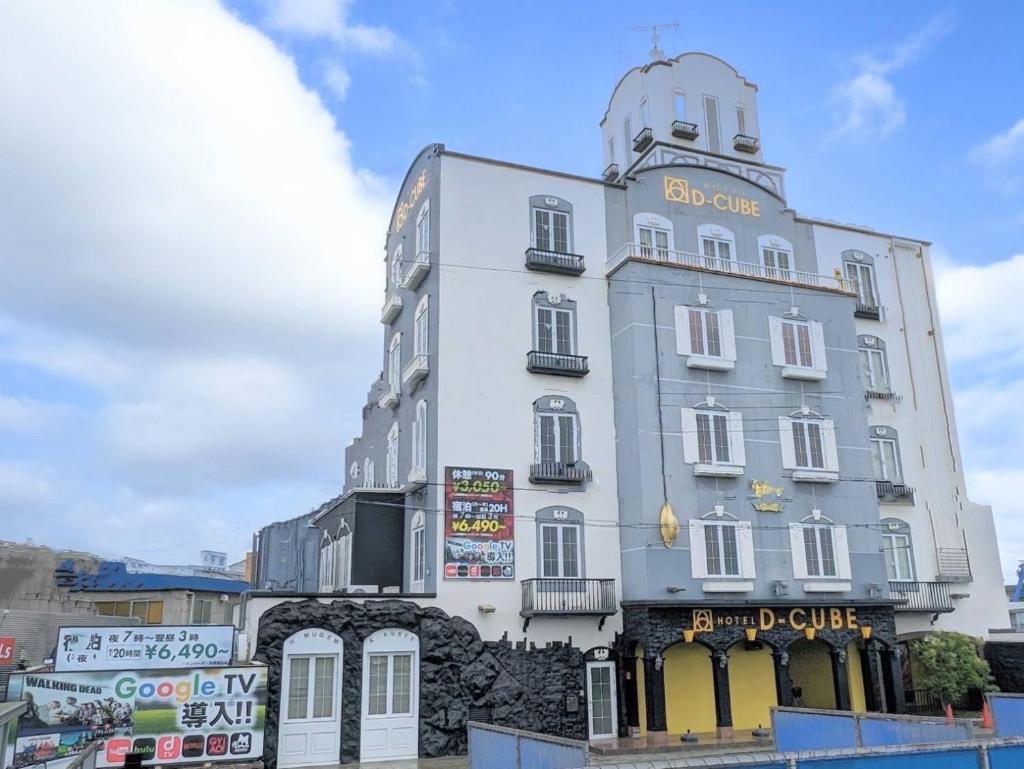 un grand bâtiment blanc avec une enseigne dessus dans l'établissement HOTEL D-CUBE 明石店, à Higashi-futami
