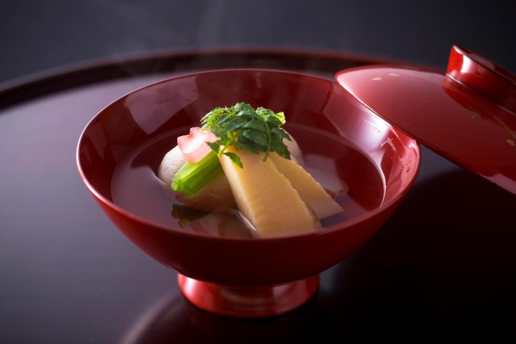 un bol rouge avec de la nourriture dedans sur une table dans l'établissement Charoku Bekkan, à Miyazu 37 autres photos