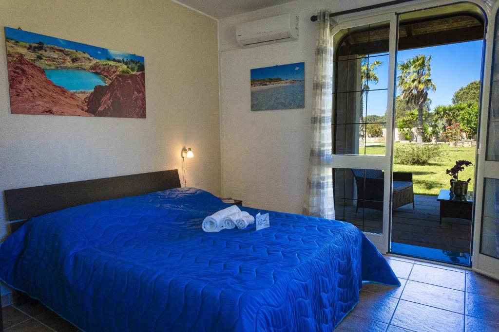 une chambre avec un lit bleu et un balcon dans l'établissement Villa El Capitano With Garden And Pool - Happy Rentals, à Muro Leccese