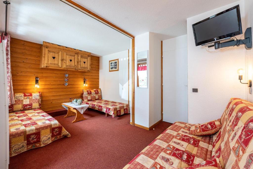 une chambre d'hôtel avec deux canapés et une télévision à écran plat dans l'établissement La Bûche, à Valmorel