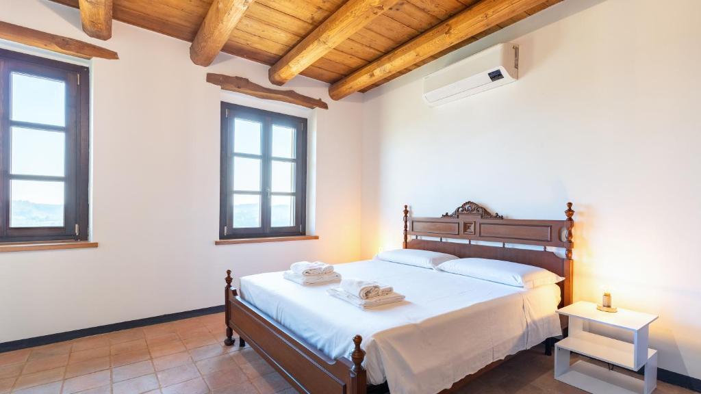 une chambre avec un lit et deux fenêtres dans l'établissement CASA LEONARDA 8, Emma Villas, à Belveglio