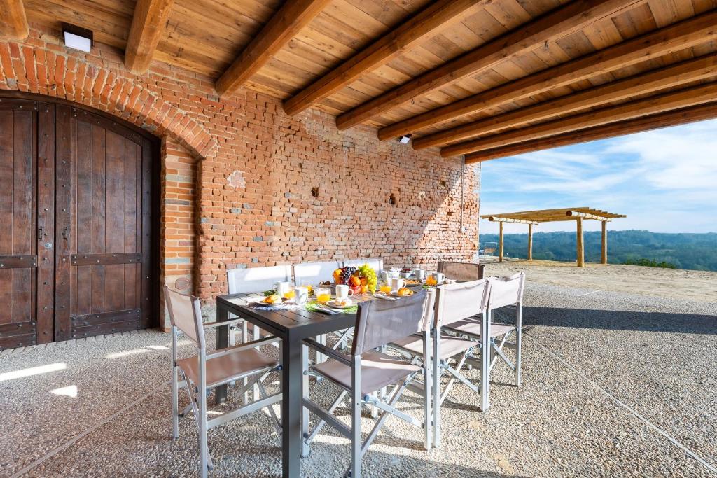 - une terrasse avec une table à manger et des chaises dans l'établissement CASA LEONARDA 8, Emma Villas, à Belveglio