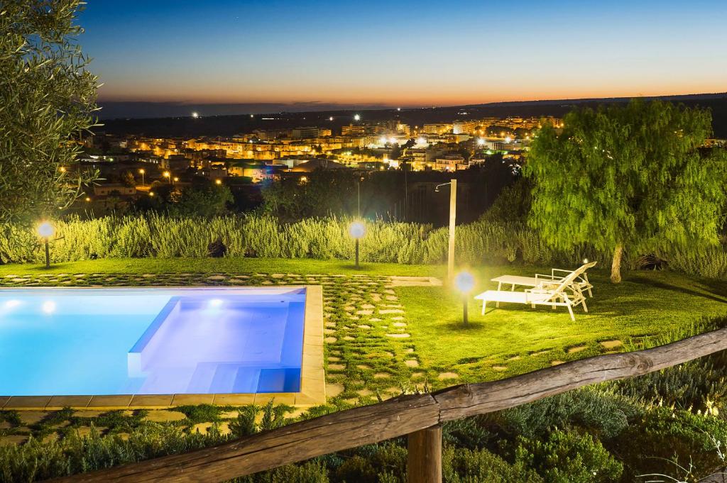 - une piscine dans une cour avec une table et un banc dans l'établissement Corte Dorata, à Scicli