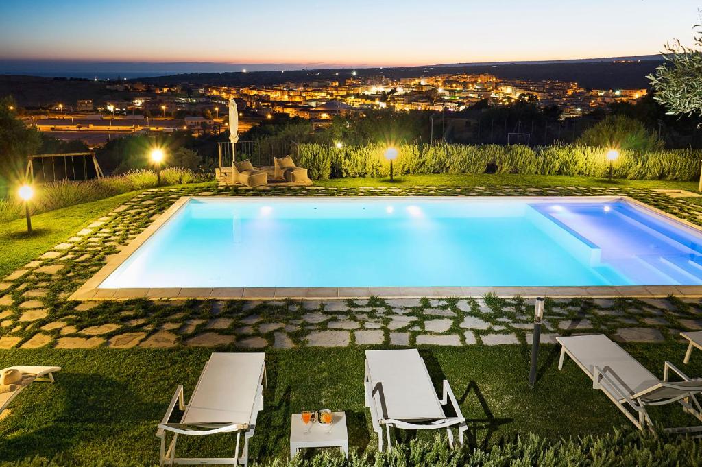 - une piscine avec 2 chaises longues dans l'établissement Corte Dorata, à Scicli