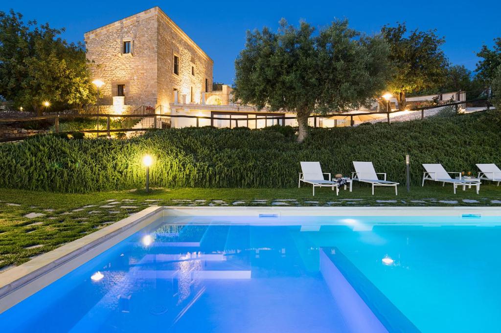 une villa avec piscine devant un immeuble dans l'établissement Corte Dorata, à Scicli