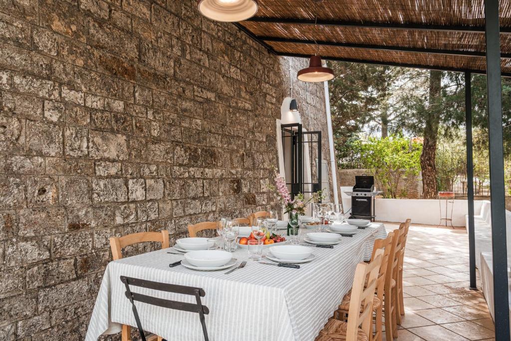 une table avec une nappe blanche sur un mur de briques dans l'établissement HelloApulia Il Mirteto, à Selva di Fasano