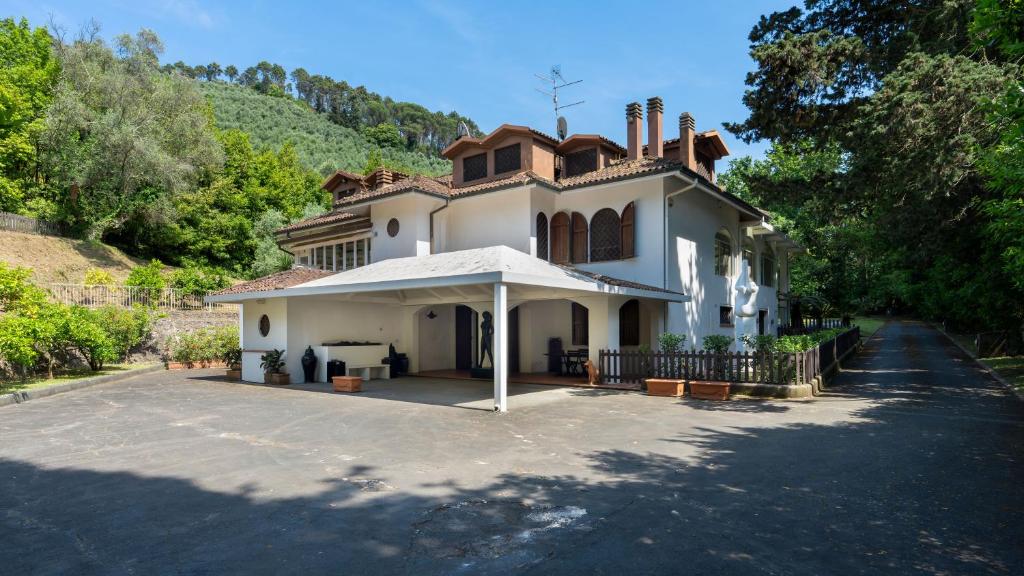 une grande maison blanche avec un toit dans l'établissement VILLA MANGANELLI 12, Emma Villas, à Camaiore
