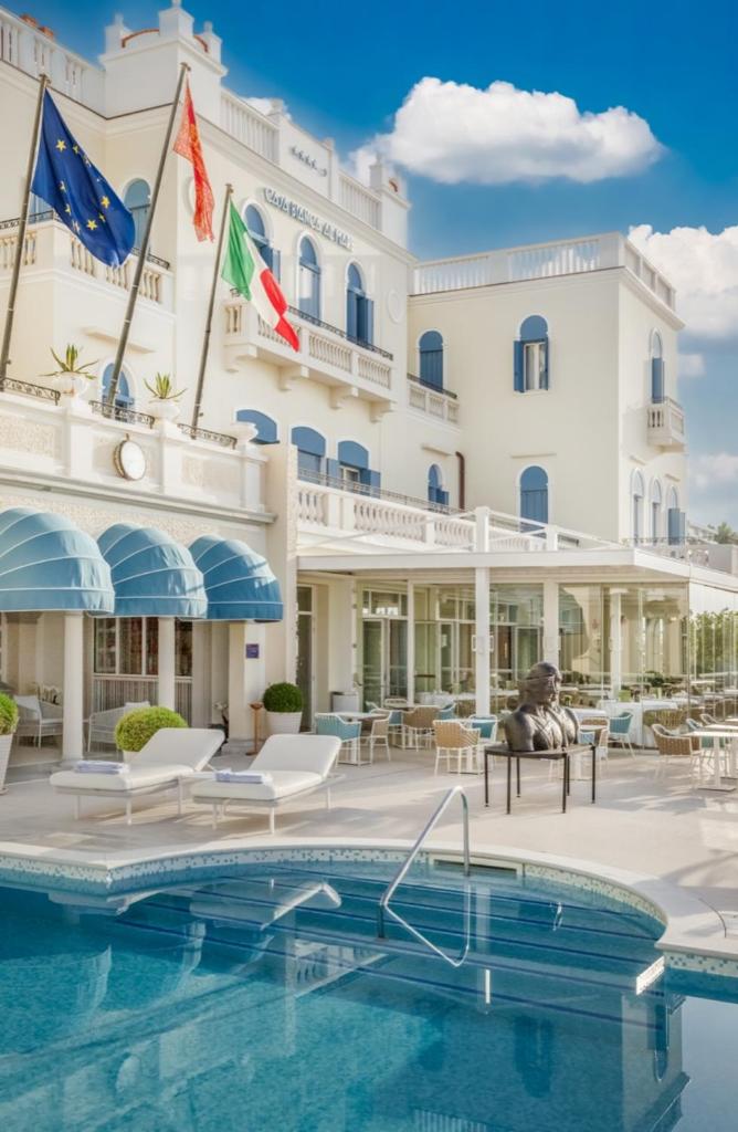 un hôtel avec une piscine devant dans l'établissement Casa Bianca Al Mare, à Lido di Jesolo