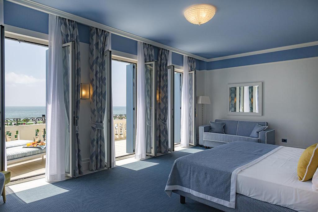 une chambre avec un lit, un canapé et des fenêtres dans l'établissement Casa Bianca Al Mare, à Lido di Jesolo 47 autres photos