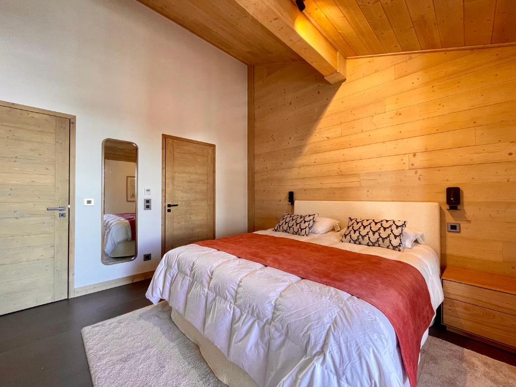 - une chambre avec un grand lit et des murs en bois dans l'établissement Homency - Résidence Phoenix B46, à L'Alpe-d'Huez