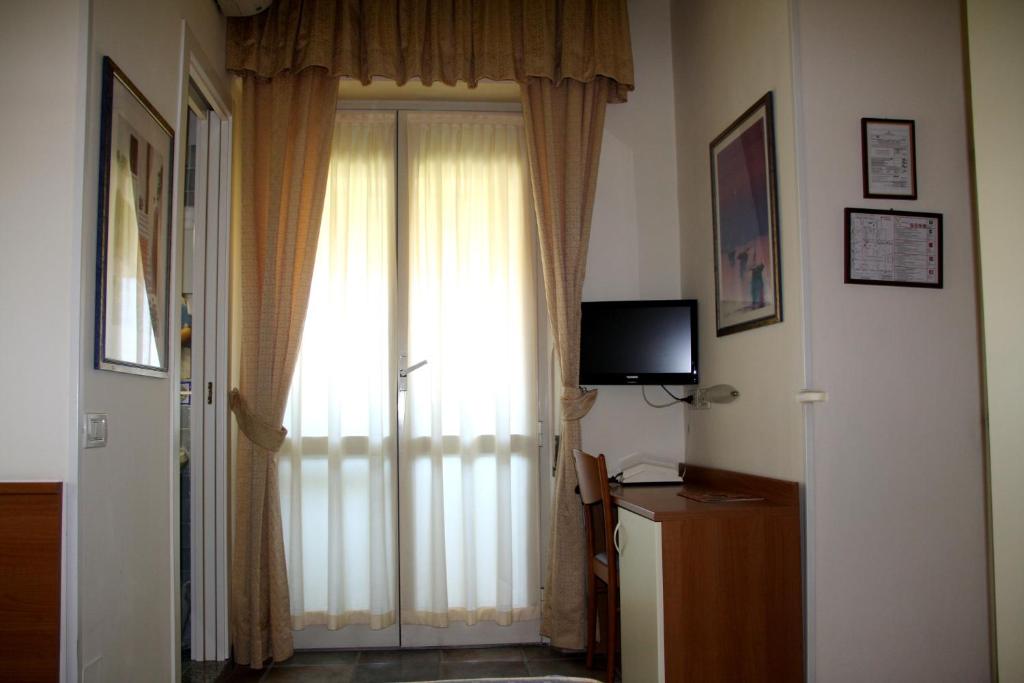 Cette chambre dispose d'une porte avec fenêtre et d'une télévision. dans l'établissement Hotel Angela, à Fano