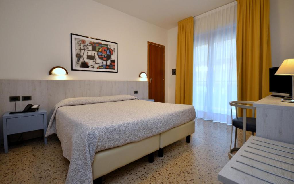 une chambre d'hôtel avec un lit et une télévision dans l'établissement Olimpia Hotel & Aparthotel, à Bibione