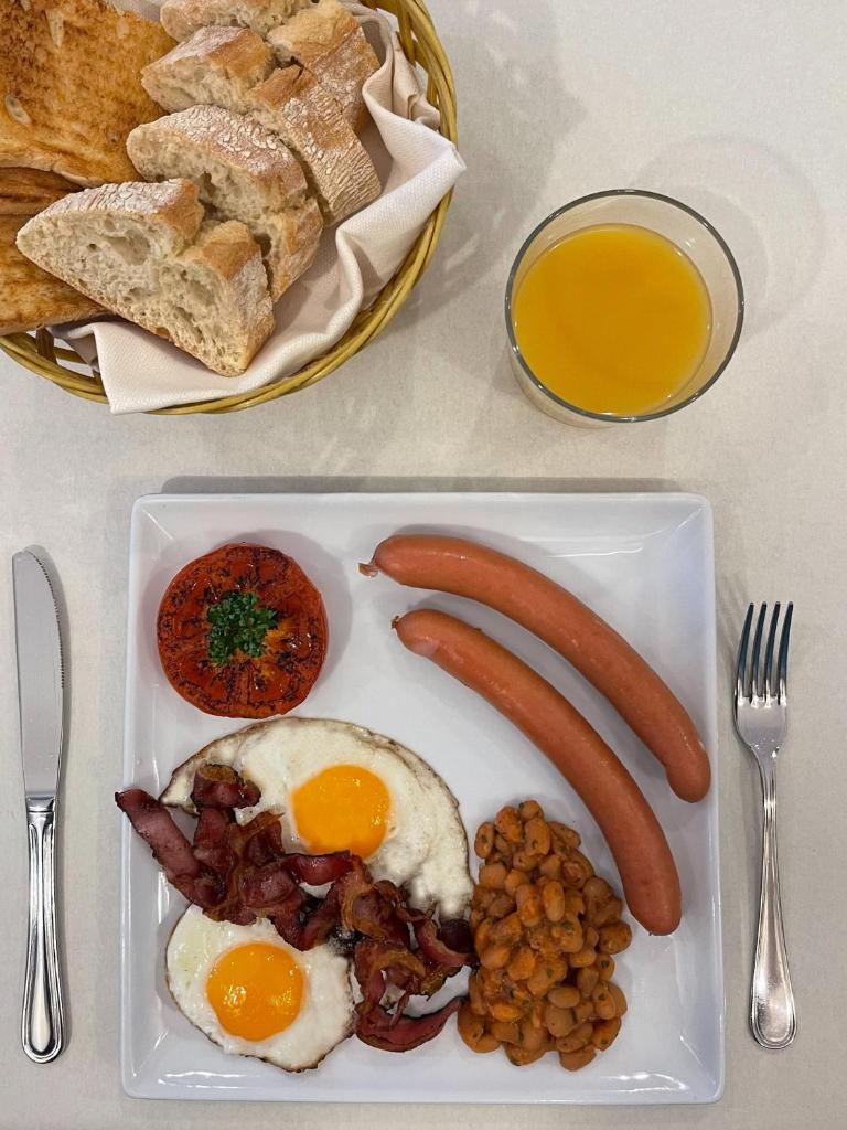 - un plateau de petit-déjeuner composé d'œufs, de saucisses et de pain dans l'établissement Olimpia Hotel & Aparthotel, à Bibione