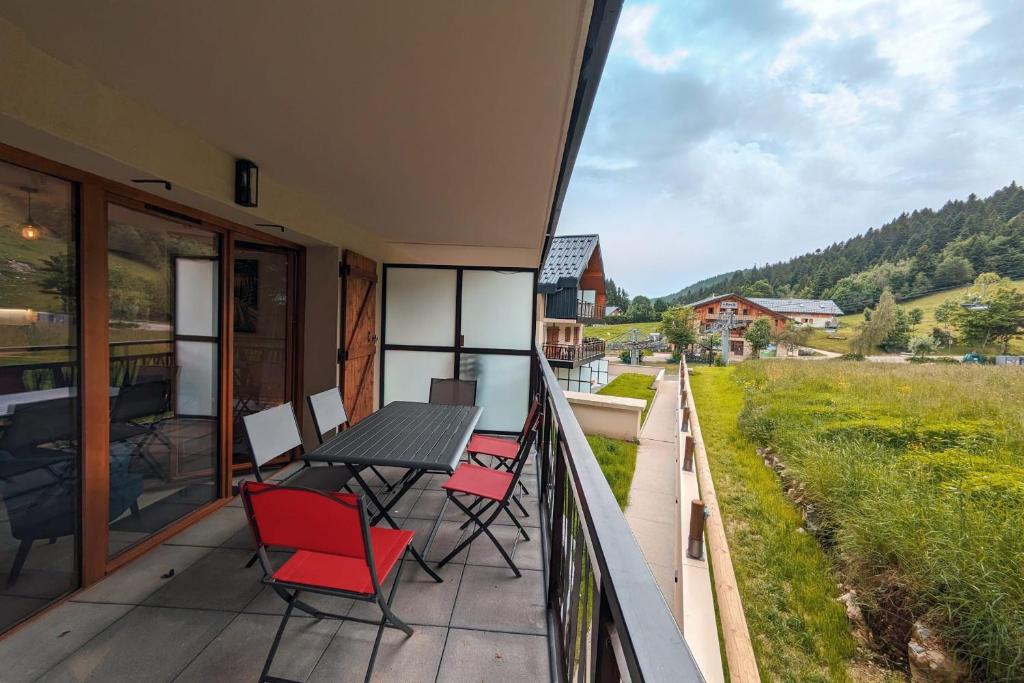 un balcon avec une table et des chaises et une vue dans l'établissement Superbe appartement au pied des pistes, à La Féclaz