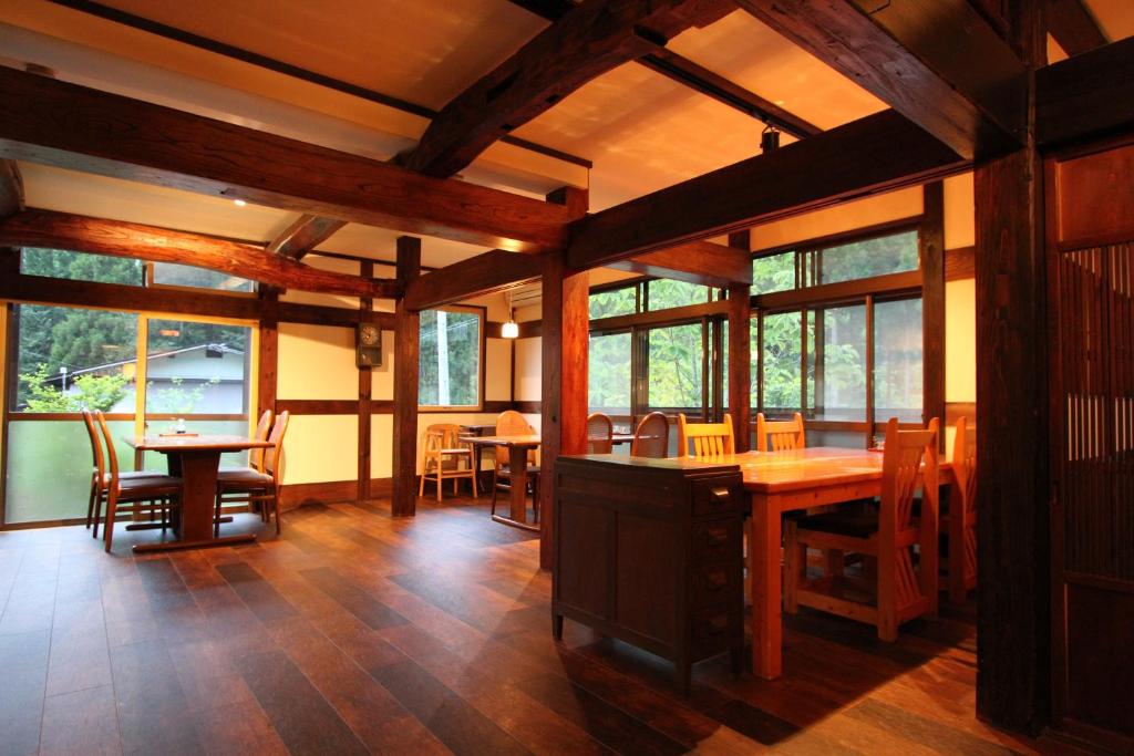 une salle à manger avec tables, chaises et fenêtres dans l'établissement Minshuku Takizawa, à Takayama