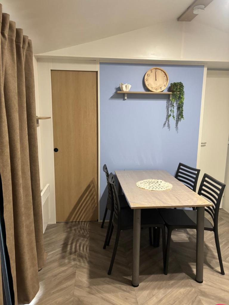 une salle à manger avec une table et une horloge au mur dans l'établissement domaine de dugny, à Onzain