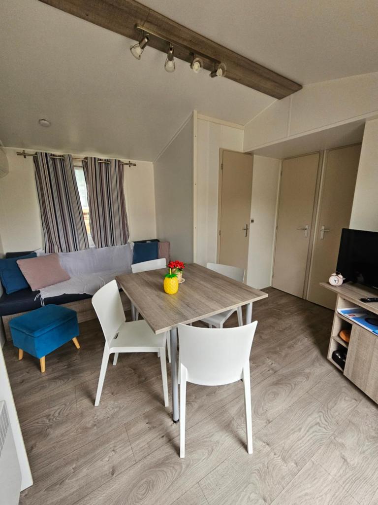 un salon avec une table et des chaises en bois dans l'établissement Mobil home climatisé 6 pers, au Muy
