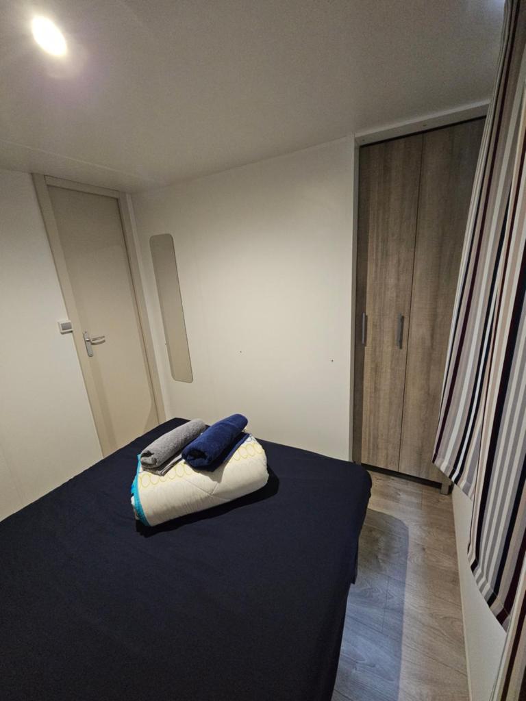une chambre avec un lit avec deux serviettes dessus dans l'établissement Mobil home climatisé 6 pers, au Muy