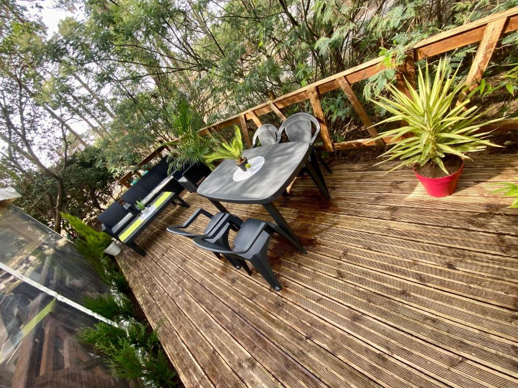 une table et des chaises assises sur une terrasse en bois dans l'établissement Camping Les Embruns Claouey Lège Cap Ferret, à Lège-Cap-Ferret