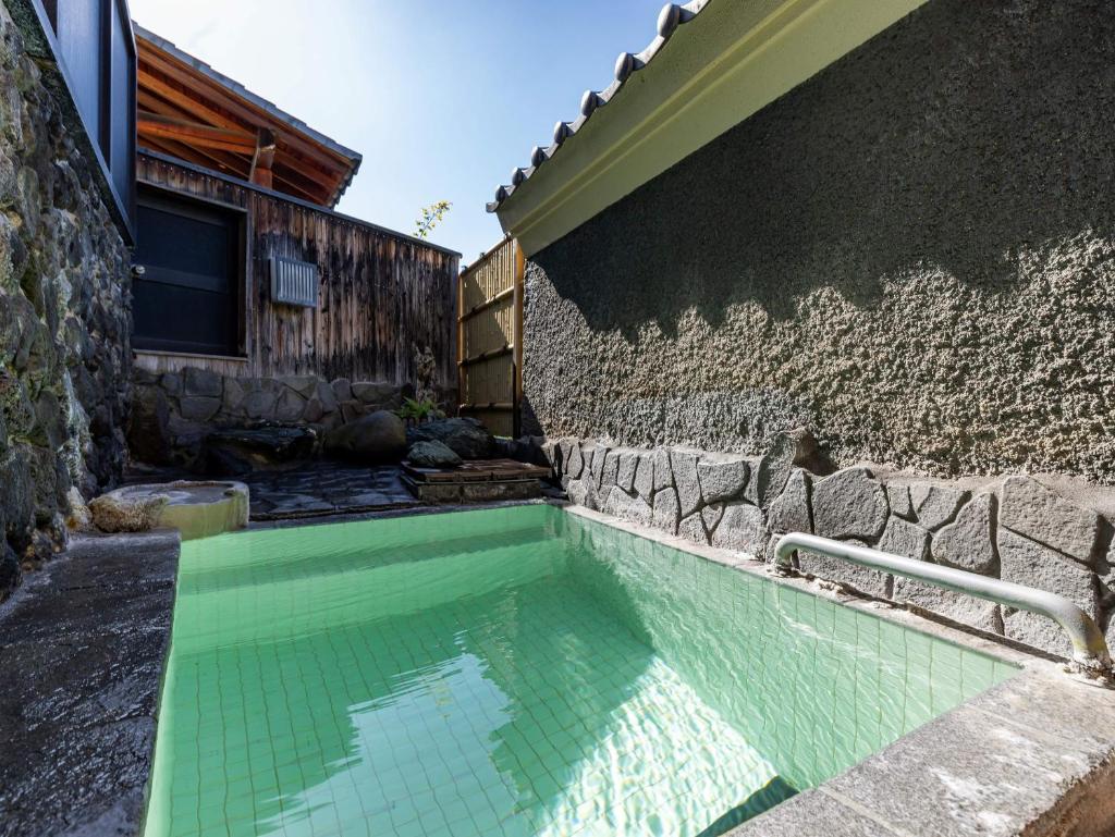 - une piscine sur le côté d'un bâtiment dans l'établissement くさつのお宿 清重館 Kiyoshigekan 素泊りの宿, à Kusatsu