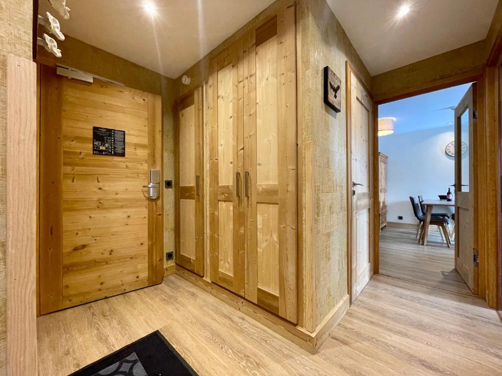 un couloir avec des murs lambrissés et une porte dans l'établissement Homency - Résidence Daria-i-Nor 202, à L'Alpe-d'Huez
