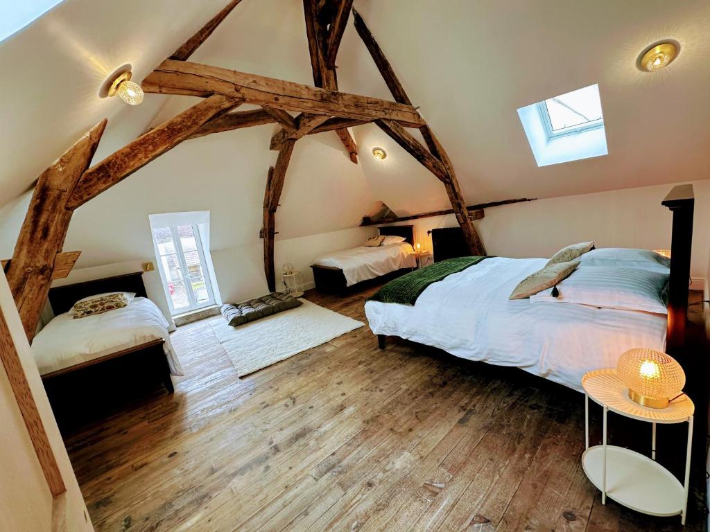 - une chambre avec 2 lits dans une chambre dotée de parquet dans l'établissement Clos Saint-Priscus - Gîte de Charme - Les Bastides d'Edouard en Bourgogne, à Saint-Bris-le-Vineux