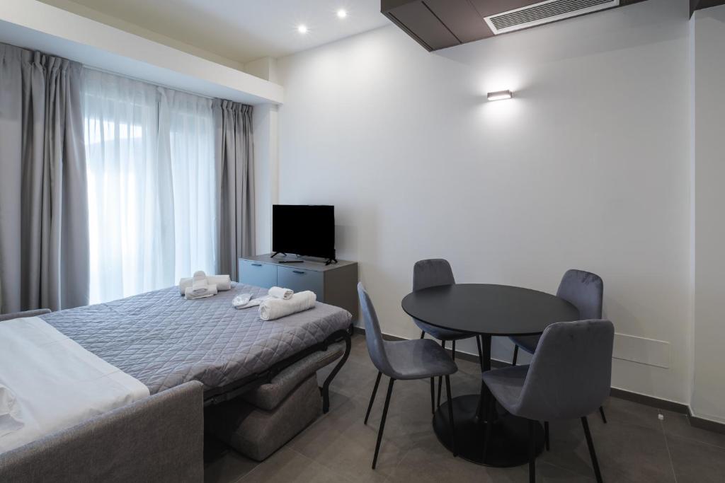 une chambre d'hôtel avec un lit, une table et des chaises dans l'établissement Residence Goldoni6 Suite Apartment, à Rimini