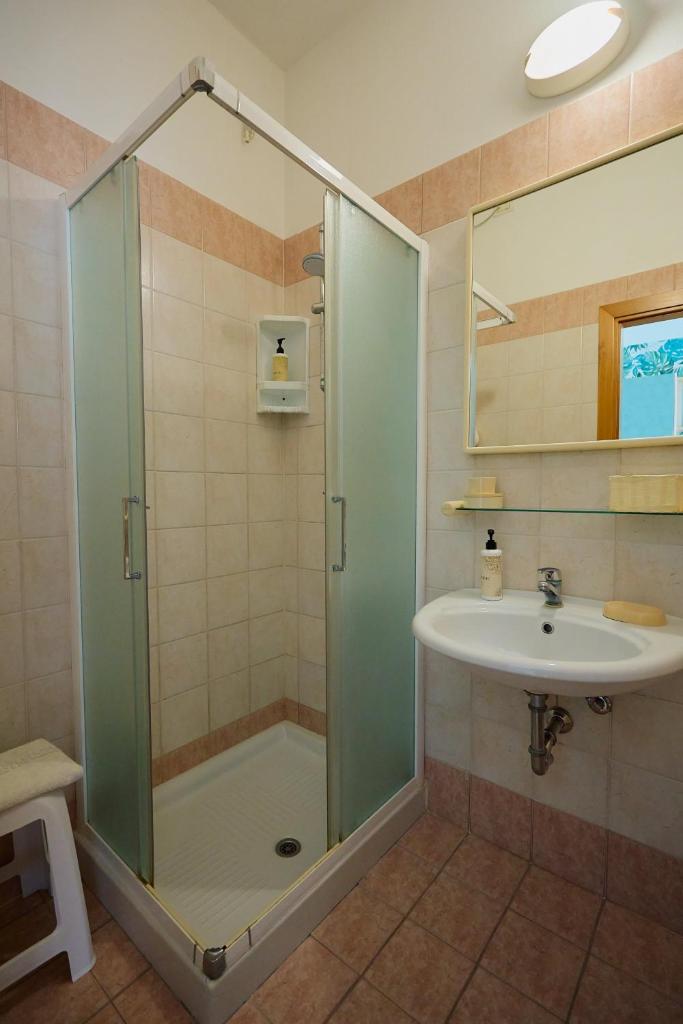une salle de bain avec douche et lavabo dans l'établissement Hotel Acquario, à Rimini