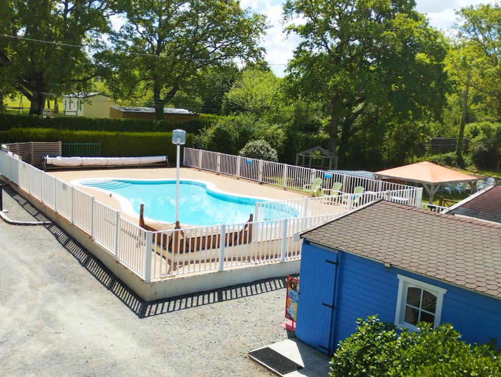 une piscine entourée d'une clôture blanche. dans l'établissement La haut, à Camoël