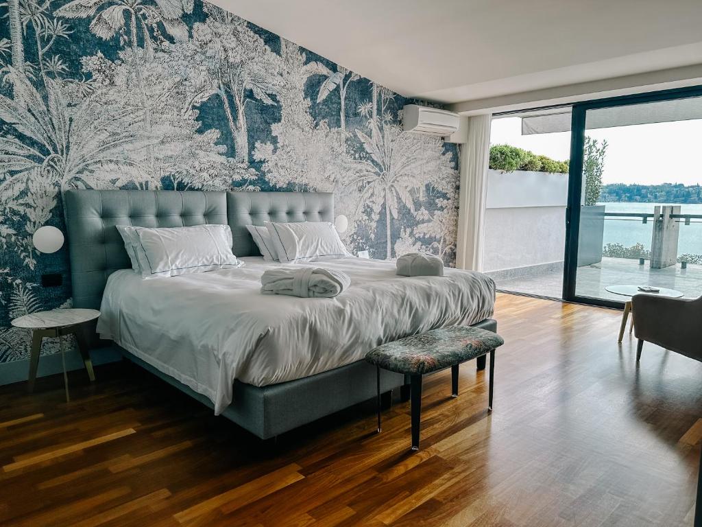 une chambre avec un grand lit et un mur de papier peint dans l'établissement Hotel Salò du Parc, à Salò 71 autres photos