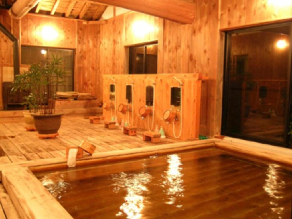 - une piscine d'eau dans une chambre dotée de murs en bois dans l'établissement Hiogiso, à Shima