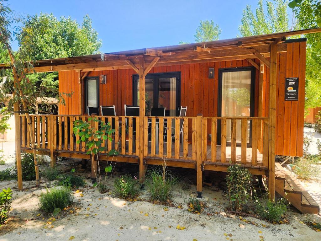 Ce chalet en bois dispose d'une véranda et d'une terrasse. dans l'établissement Mobil Homes Vacances, à Grimaud