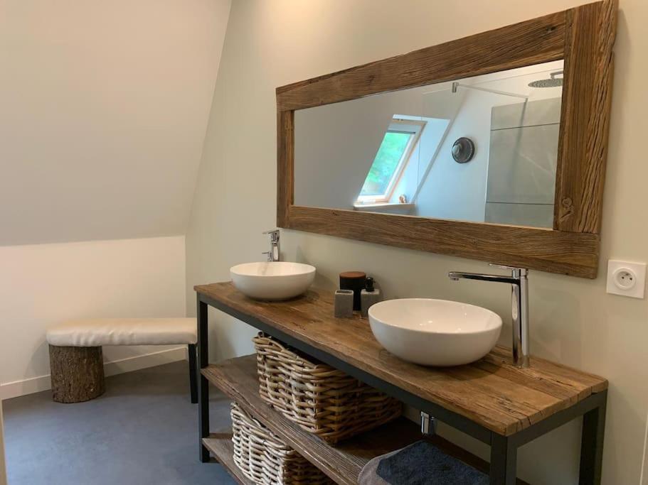une salle de bain avec deux lavabos et un grand miroir dans l'établissement Gîte Nature, à Marcolès