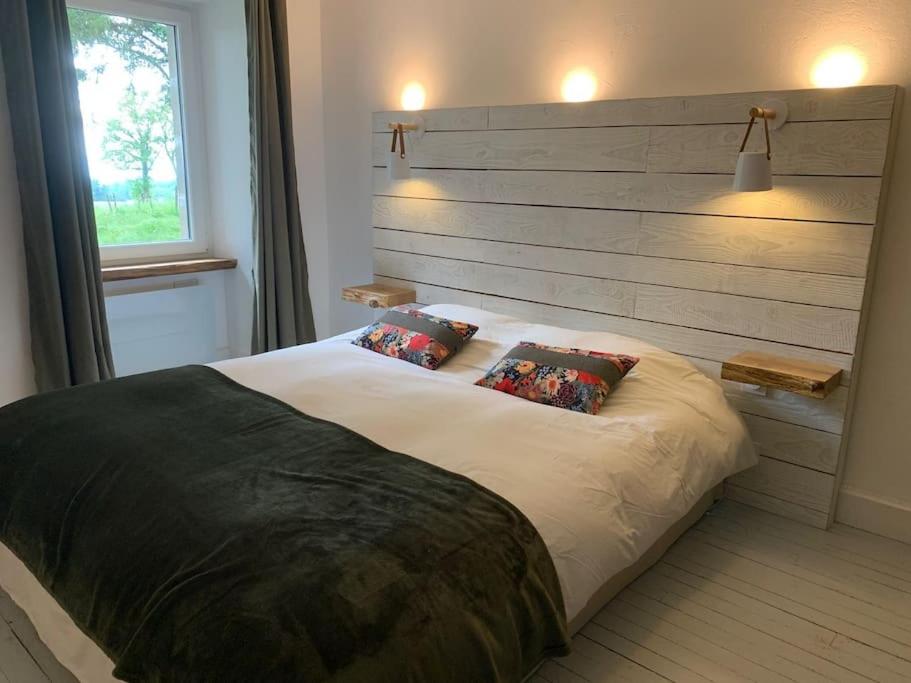 une chambre avec un grand lit avec deux oreillers dans l'établissement Gîte Nature, à Marcolès