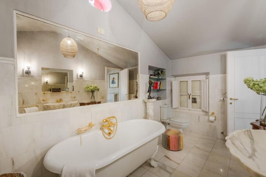 une salle de bain avec une baignoire, des toilettes et un lavabo dans l'établissement La Chiesetta a charming Church converted into Farmhouse with Pool, à Lucques 88 autres photos