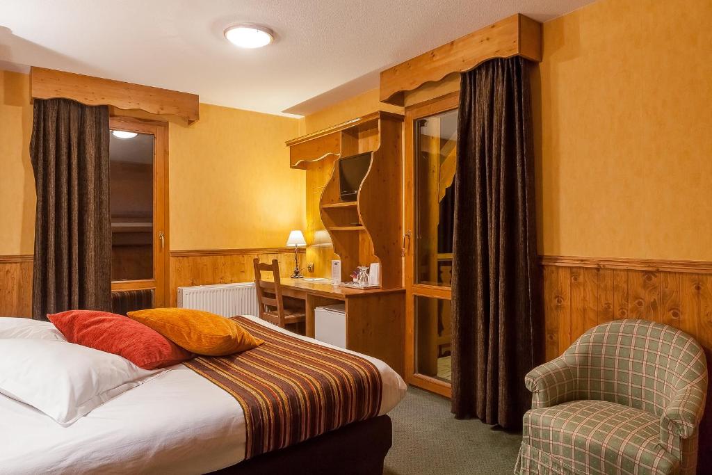 une chambre d'hôtel avec un lit et une chaise dans l'établissement Hôtel Les Balcons Village, à Belle Plagne 37 autres photos