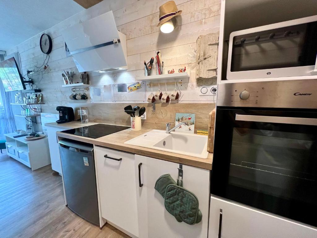 une petite cuisine avec un évier et un micro-ondes dans l'établissement Studio paisible au pied des pistes, à Villard-de-Lans