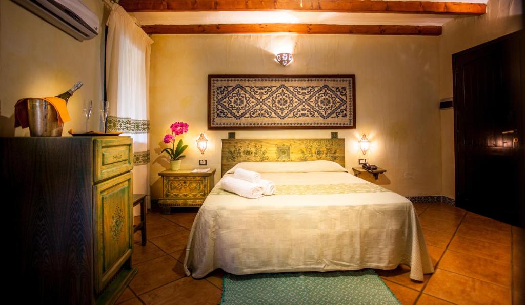 - une chambre avec un lit doté d'un couvre-lit blanc et d'une fenêtre dans l'établissement Hotel Fiore Di Maggio, à Villasimius