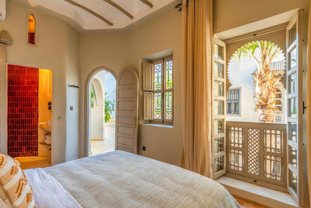 une chambre avec un lit et un balcon dans l'établissement Suites & Spa BY XO-RIAD, à Marrakech