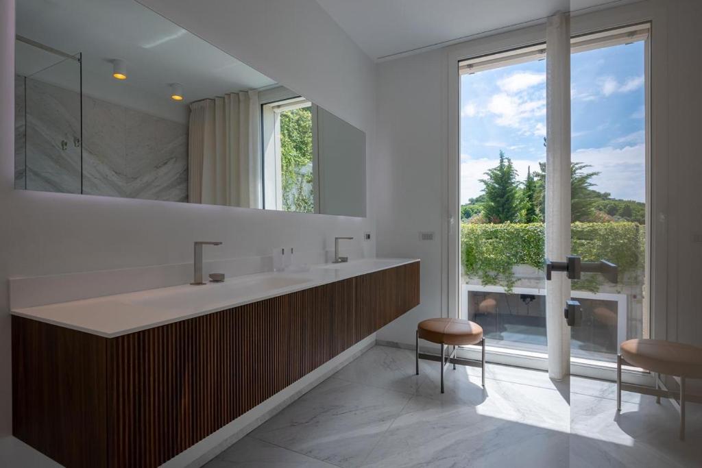une salle de bain avec un grand lavabo et une grande fenêtre dans l'établissement Villa Diamante del Garda & Spa, à Toscolano Maderno