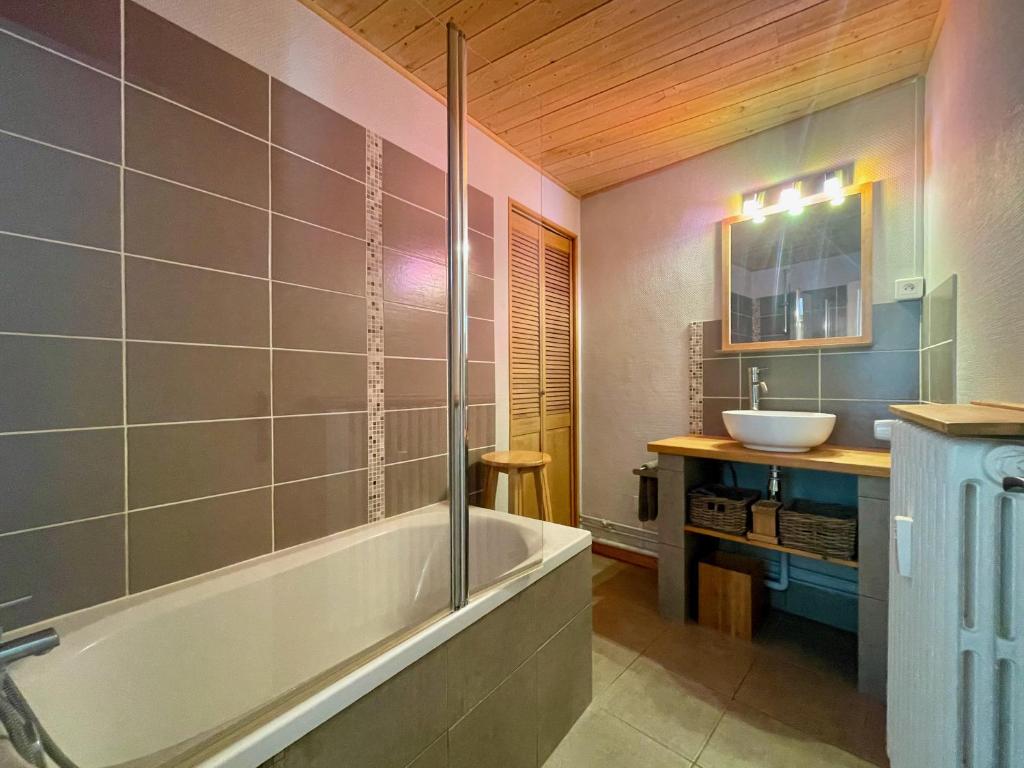 une salle de bain avec une baignoire et un lavabo dans l'établissement Homency - Résidence de l'Oisans C0, à L'Alpe-d'Huez