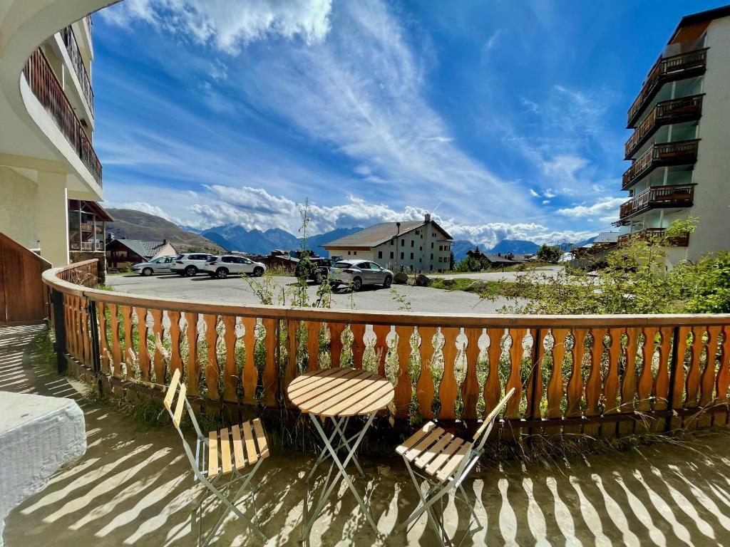 - deux chaises sur un balcon avec vue sur les montagnes dans l'établissement Homency - Résidence de l'Oisans C0, à L'Alpe-d'Huez