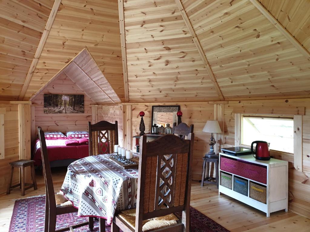 une chambre avec un lit dans une cabane en bois dans l'établissement White wood kota, à Nonville