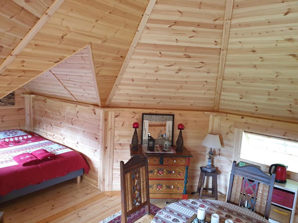 - une chambre dans une cabane en rondins avec un lit et un miroir dans l'établissement White wood kota, à Nonville