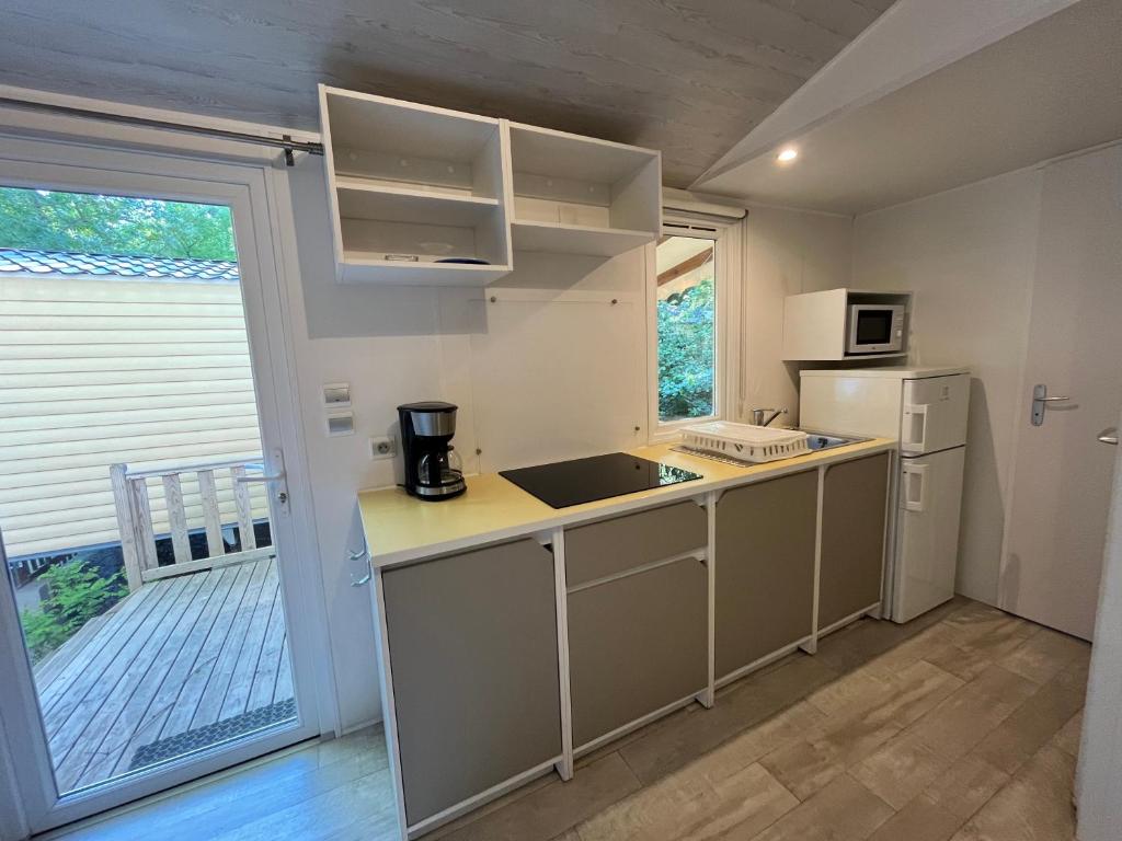une petite cuisine avec un évier et un réfrigérateur dans l'établissement Camping du Pont d'Avignon, à Avignon 18 autres photos