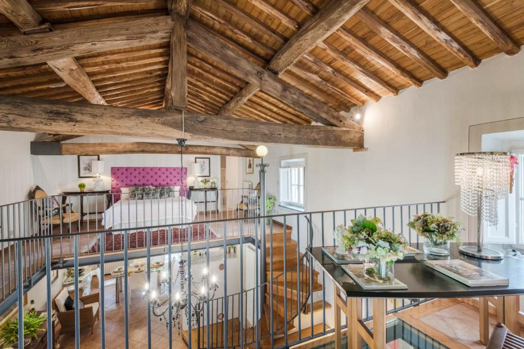 Elle comprend un salon doté de plafonds en bois et d'une table en verre. dans l'établissement La Chiesetta a charming Church converted into Farmhouse with Pool, à Lucques