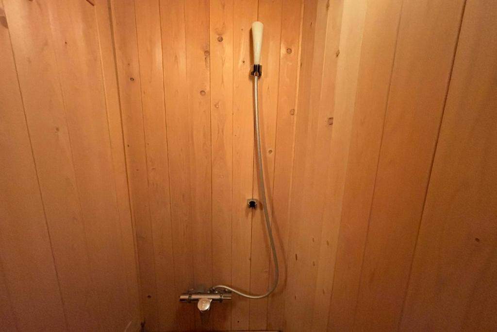 une salle de bain avec un mur en bois avec une douche dans l'établissement Kira No Sato, à Itō 53 autres photos