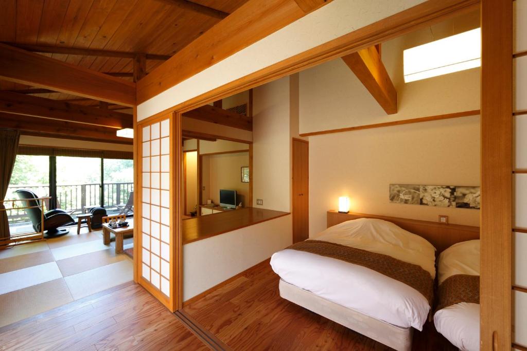une chambre avec un grand lit et un salon dans l'établissement Kira No Sato, à Itō